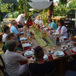 Ein großer Tisch hinter Juttas Kochbar - und viele Gespräche
